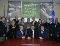 The photo shows Robert Lapointe, Assistant Operations Director, in the centre with STO Chairman Patrice Martin on the right and STO General Manager Michel Brissette on the left. They are surrounded by a few members of the Board of Directors and several STO executives.